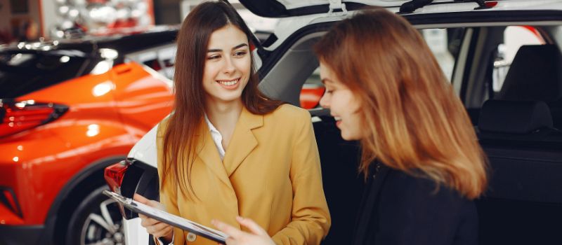 a photo of a cae dealer and a client