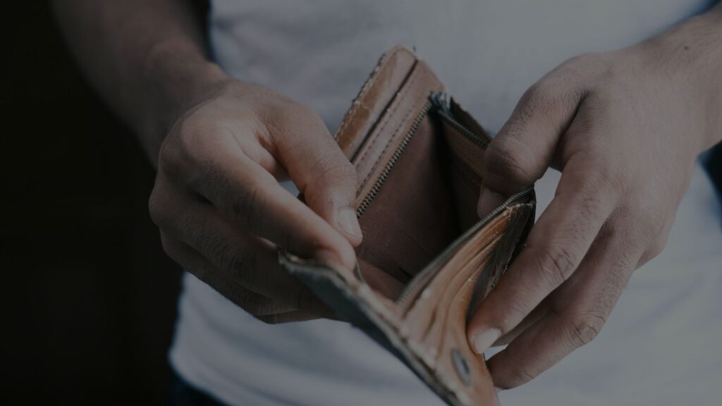 a man holding his wallet without any penny