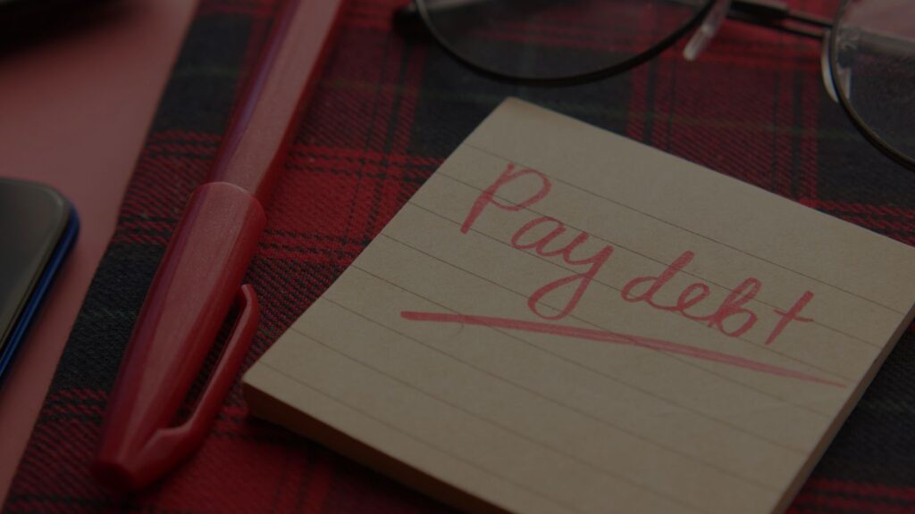 a paper that has pay debt written on it