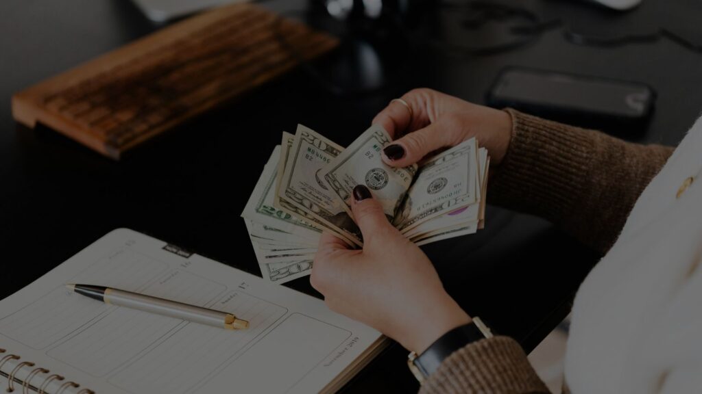 a person counting money and doing some documents