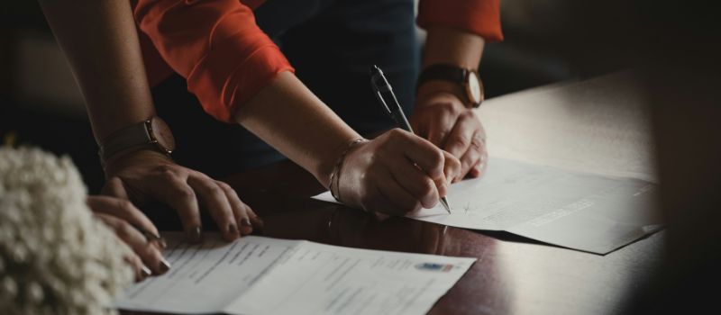 a photo of a person signing a document