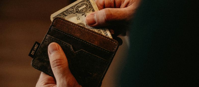 a person holding his wallet and money