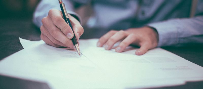 photo of a man signing a documents
