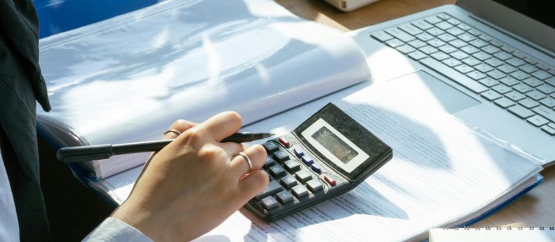 hands holding a pen and calculating