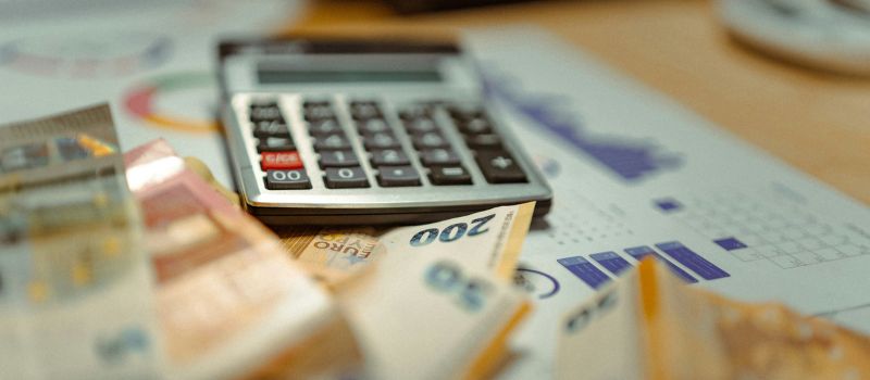 image of a tax document, a money, and a calculator