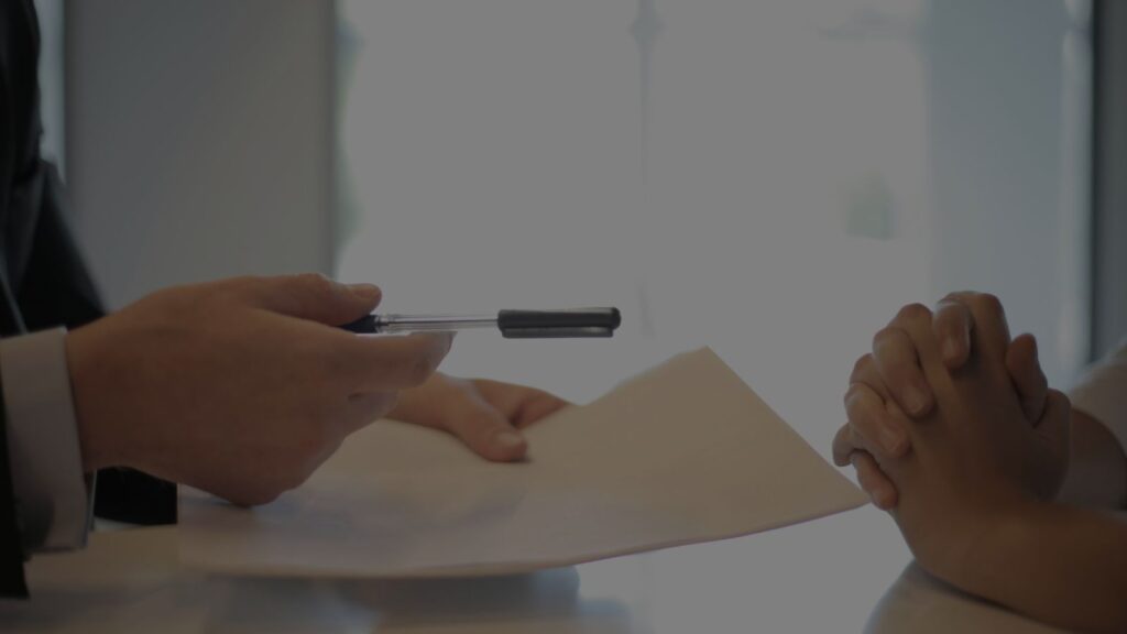 a person holding a pen and paper