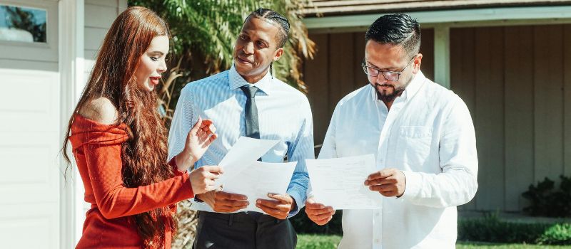 three persons holding a paper