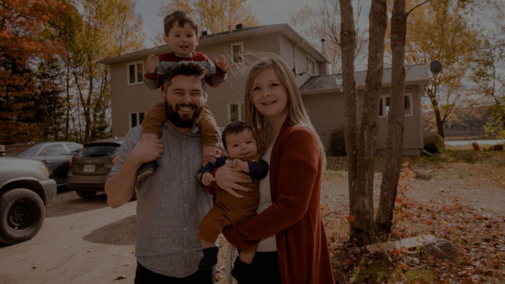 a happy family standing in front of their house