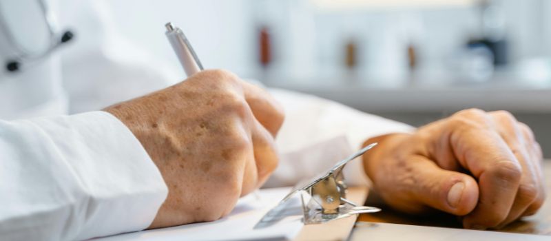 a person writing his clipboard 