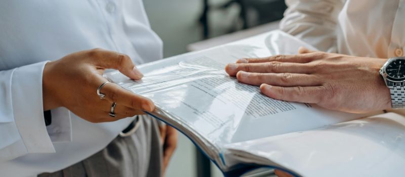 two persons holding some important files