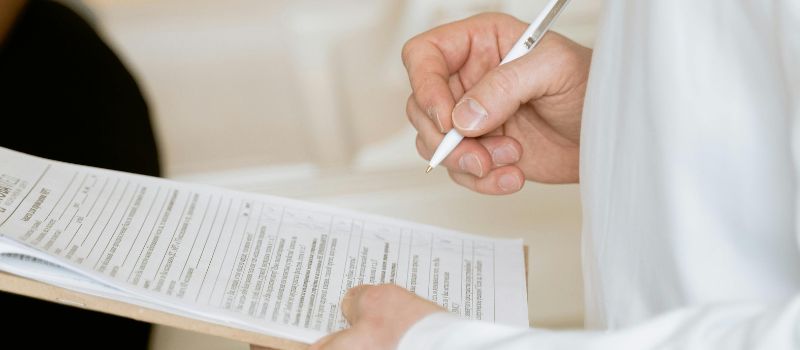 a person holding a pen and documents