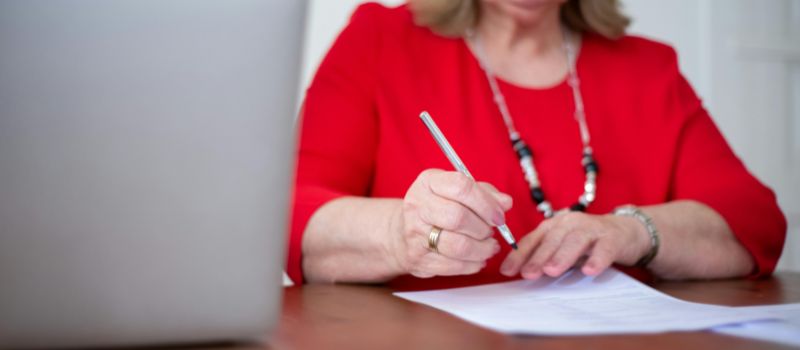 a person holding a pen and a piece of paper