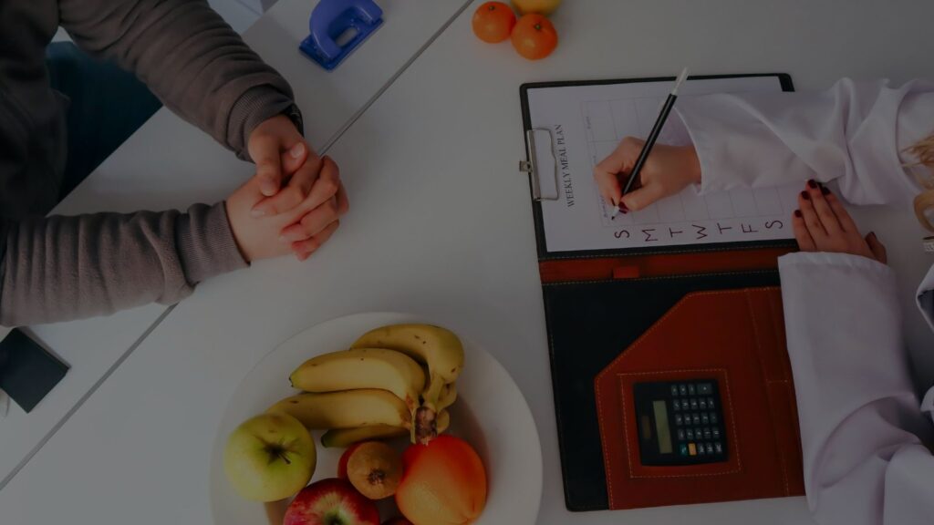 a photo of a nutritionist or dietitian in consultation with a patient