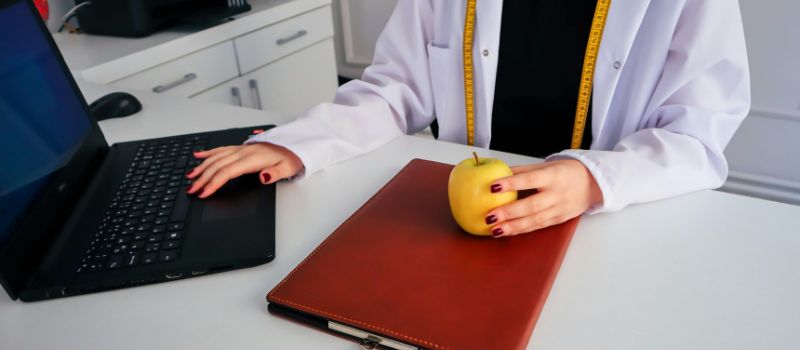 a dietician holding a fruit 
